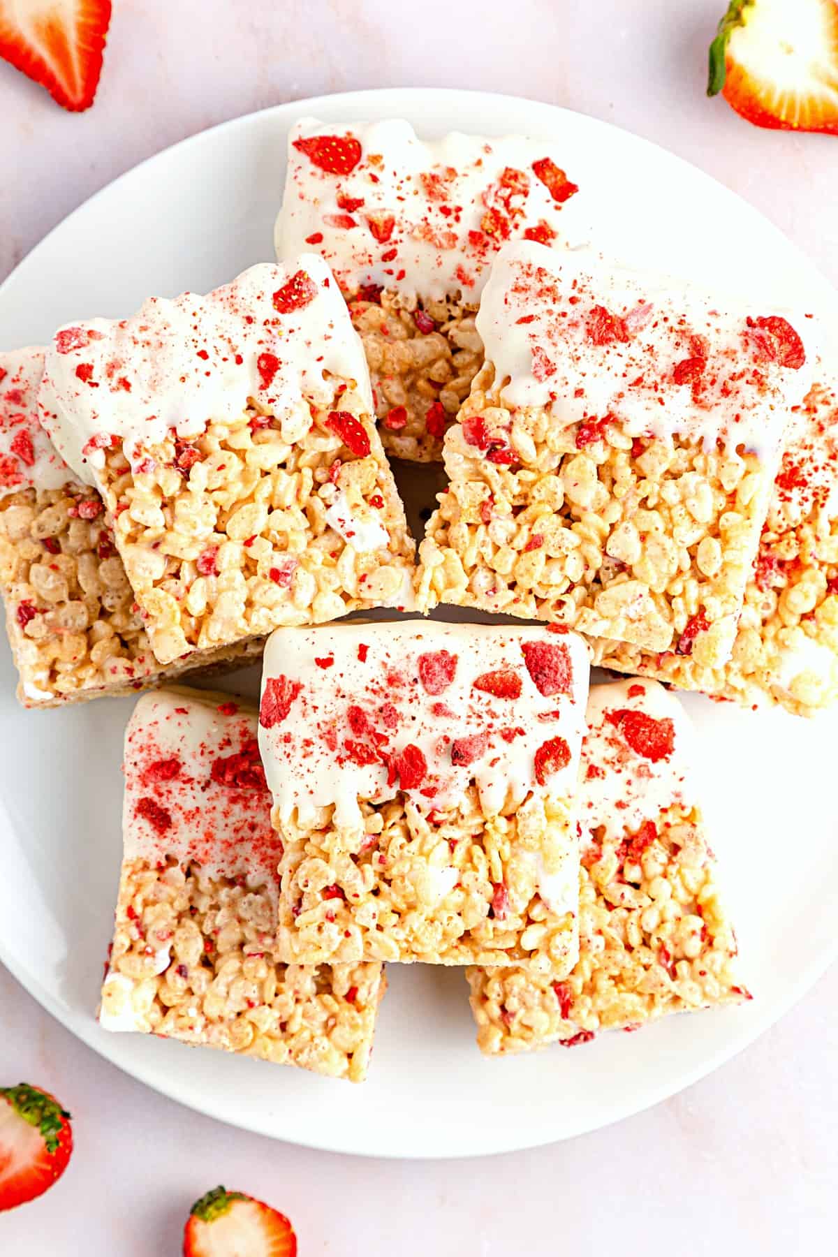 A plate full of strawberry rice krispie treats.