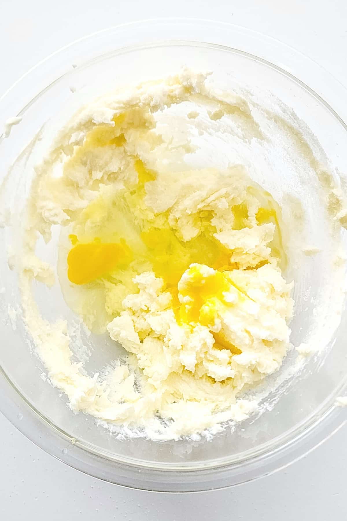 Egg and dough mixture in glass bowl.