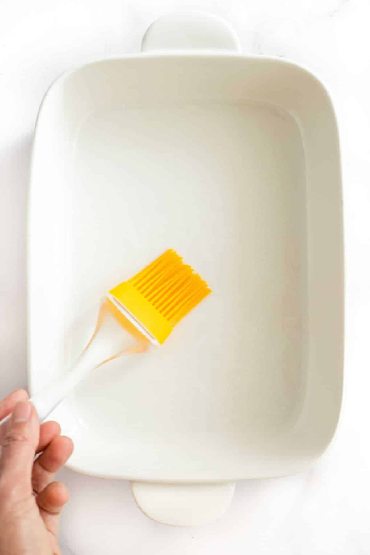 Using silicon brush to grease casserole dish.