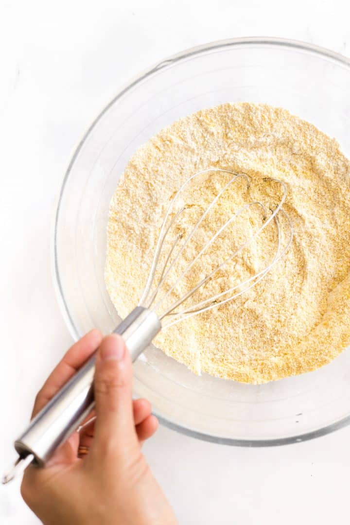 Whisking dry ingredients in glass mixing bowl.