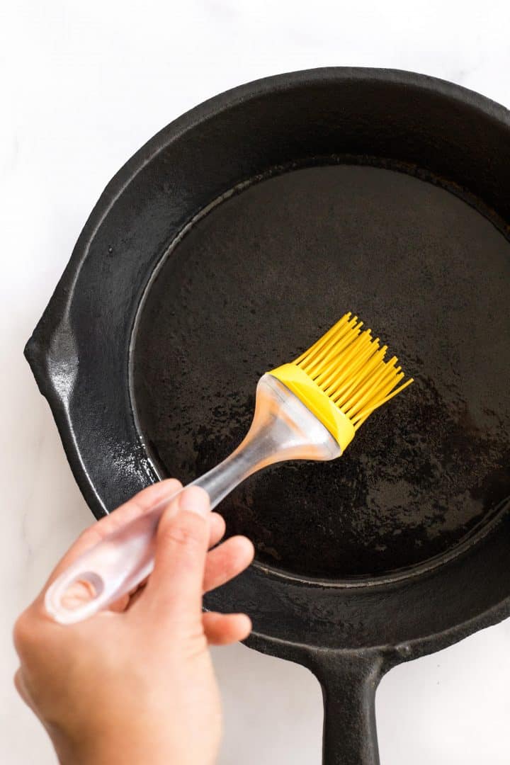 Brushing cast iron skillet with oil