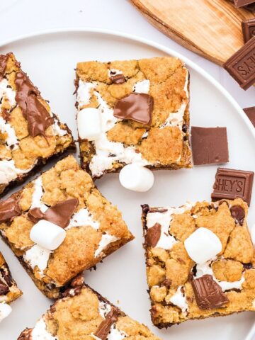 A plate of gluten-free s'mores bars with chopped chocolate at the side.