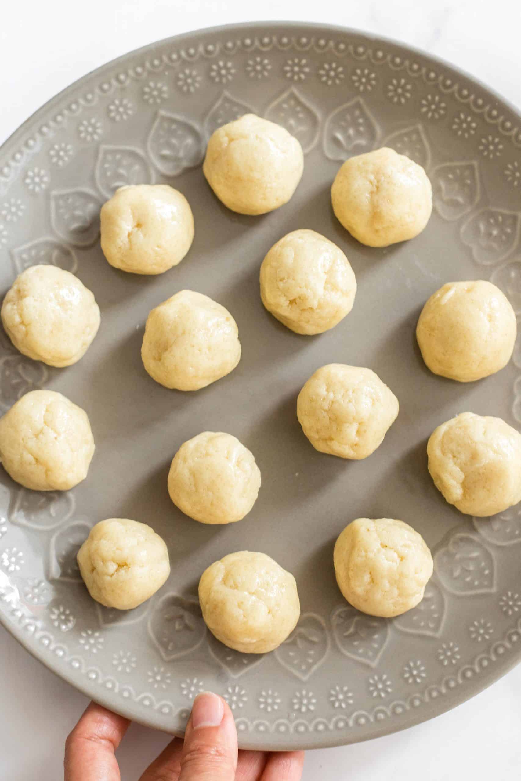 Snickdoodle cookie dough balls on a plate.