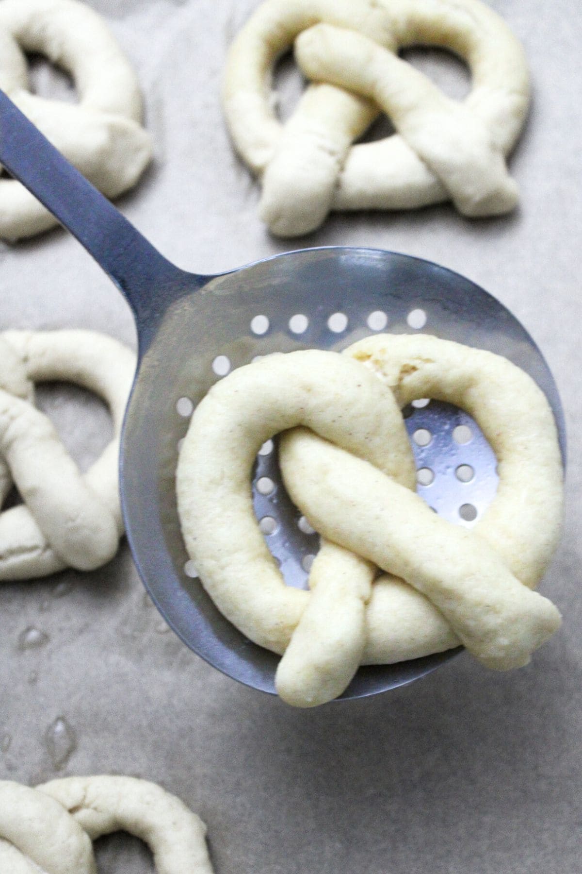 Pretzel dough on slotted spoon