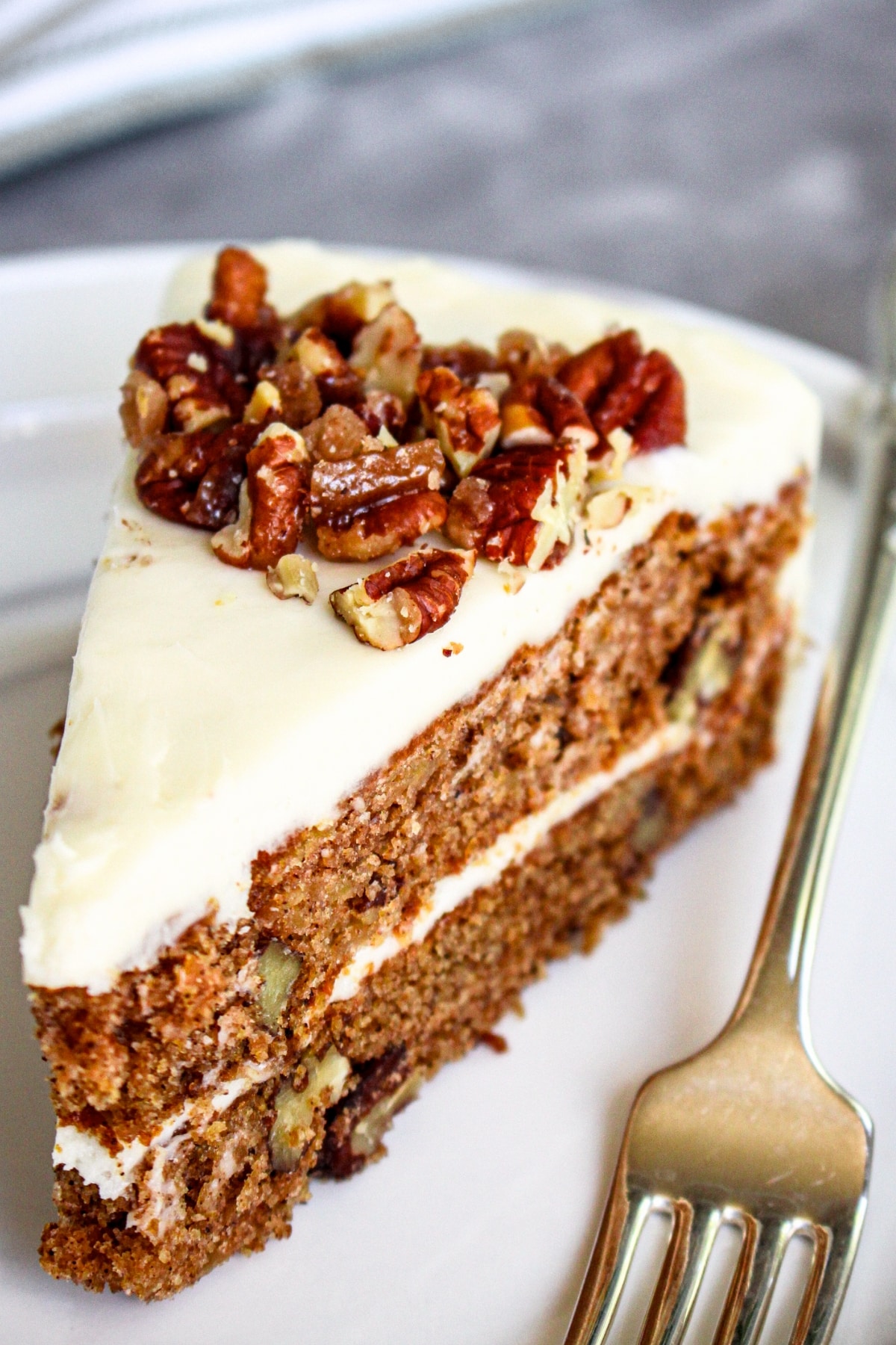 Up close shot of a slice of gluten-free spice cake and a fork on white plate.