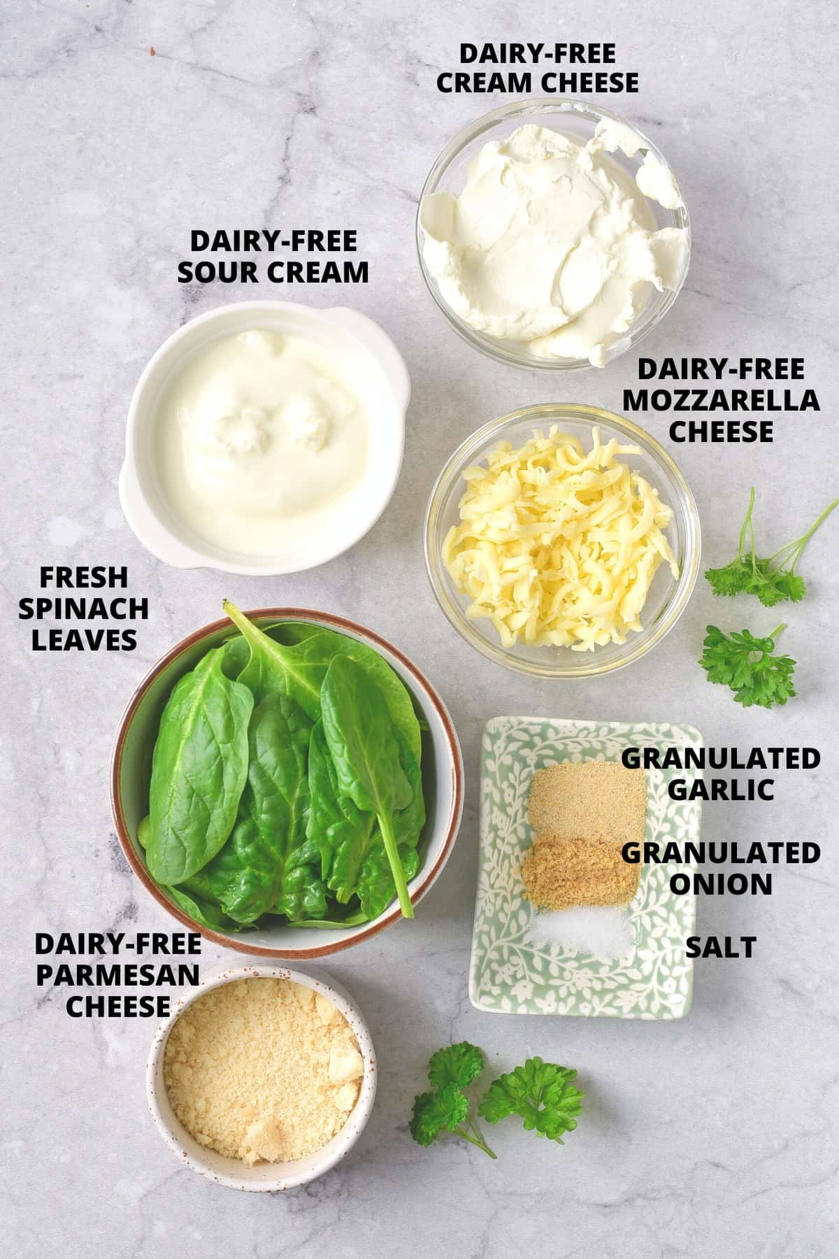 Ingredients for gluten-free spinach dip recipe laid out on marble board.