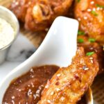 Chicken wing dipped in dark brown sauce