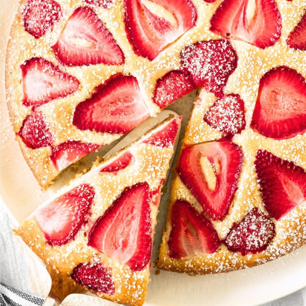 Reaching for a slice of strawberry cake