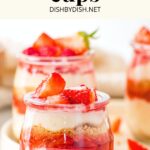 Cheesecake cups with strawberries on plate.