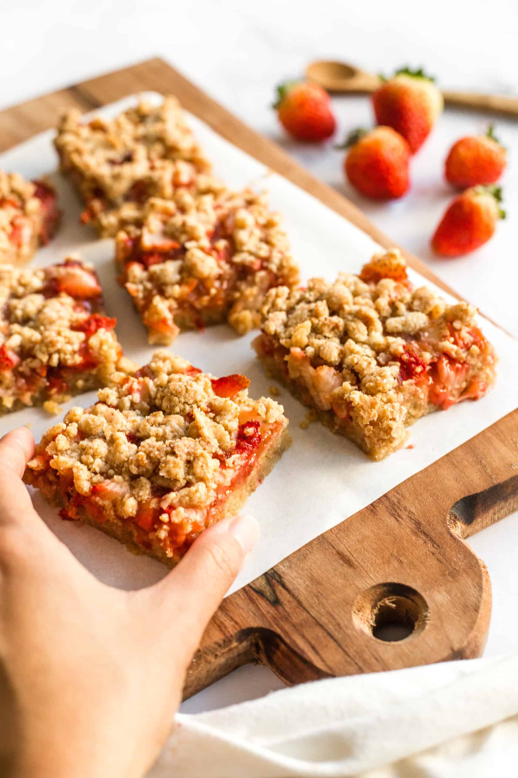 Gluten-free strawberry crumb bars on a wooden board