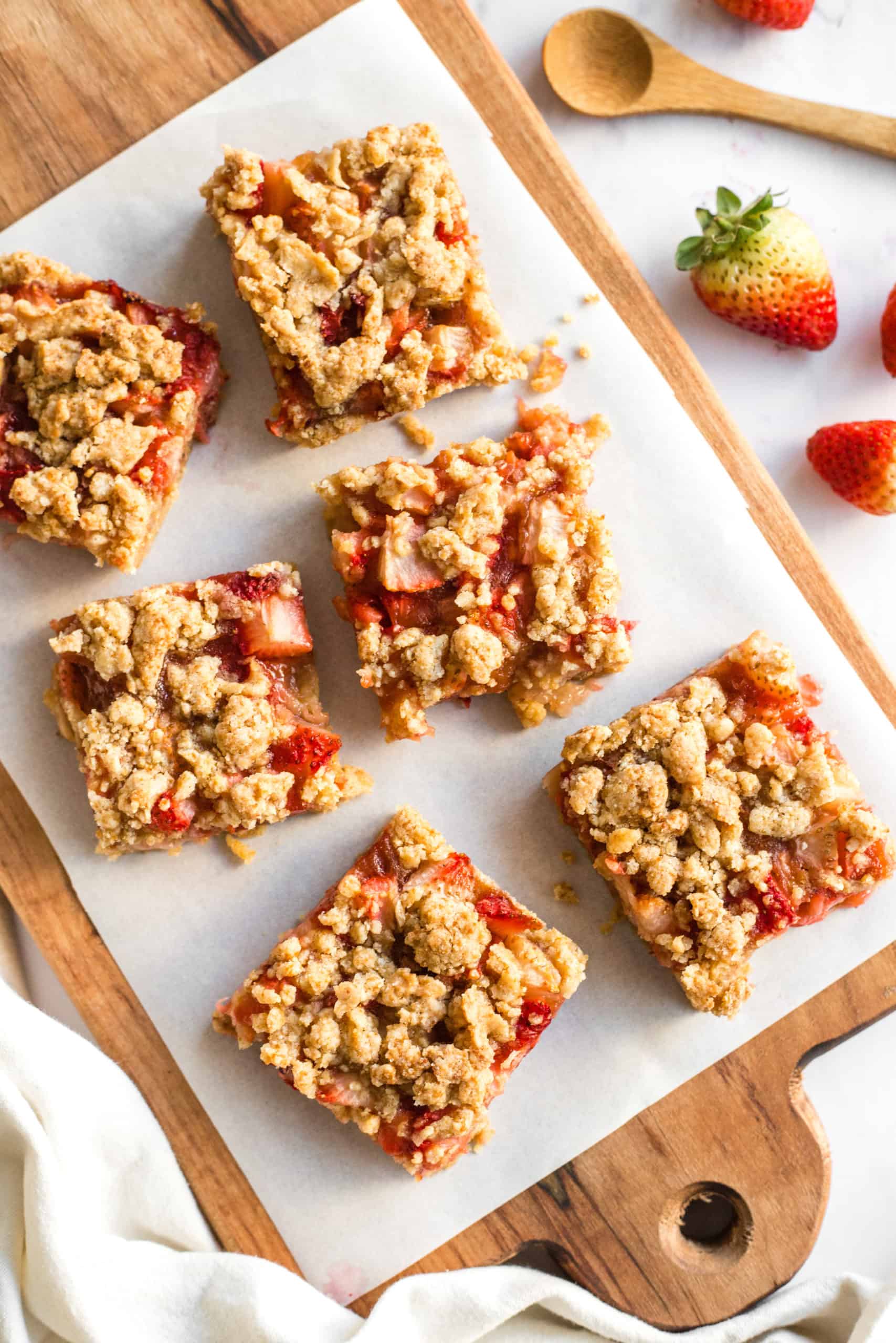 gluten-free strawberry crumble bars on a wooden board.