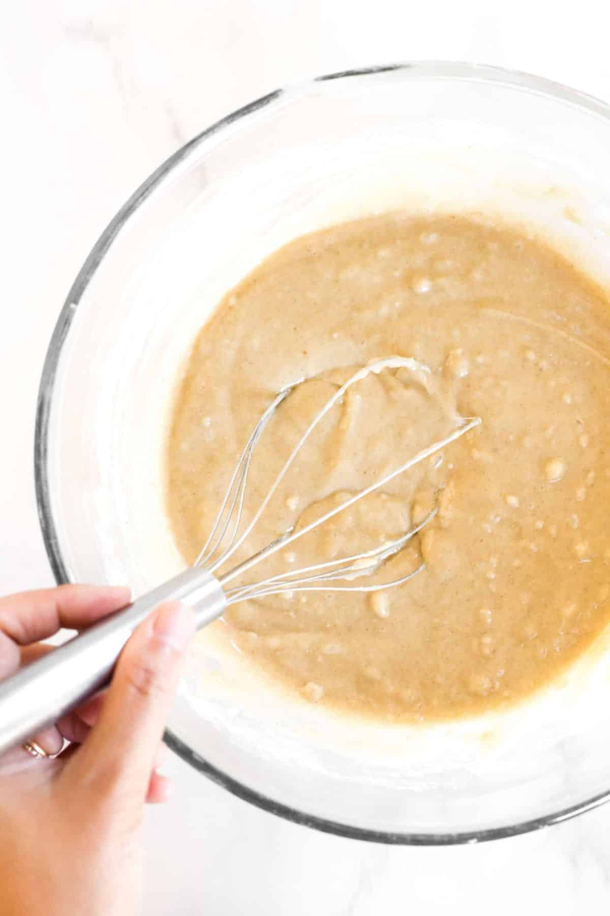 Mixing muffin mixture in glass bowl.