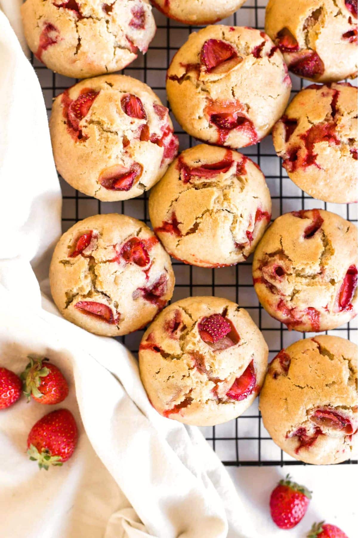 Strawberry gluten-free muffins resting on wire rack.