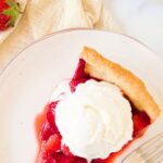 A slice of strawberry pie topped with ice cream