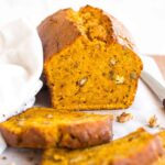 A half-sliced loaf of sweet potato quick bread