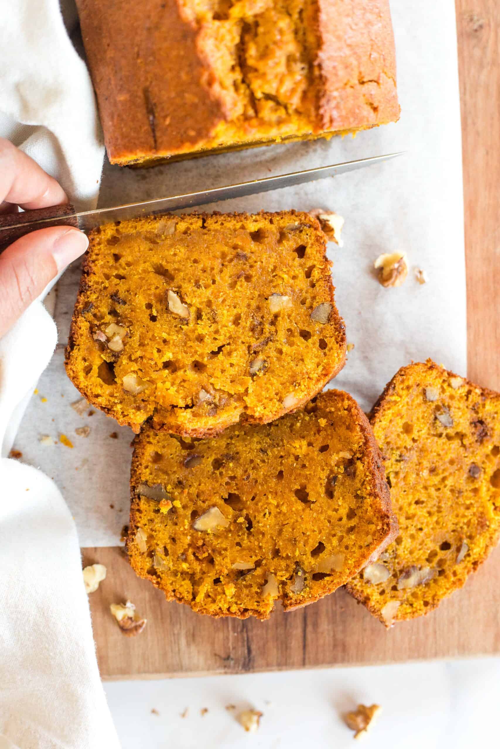 Slicing into a gluten-free sweet potato loaf.