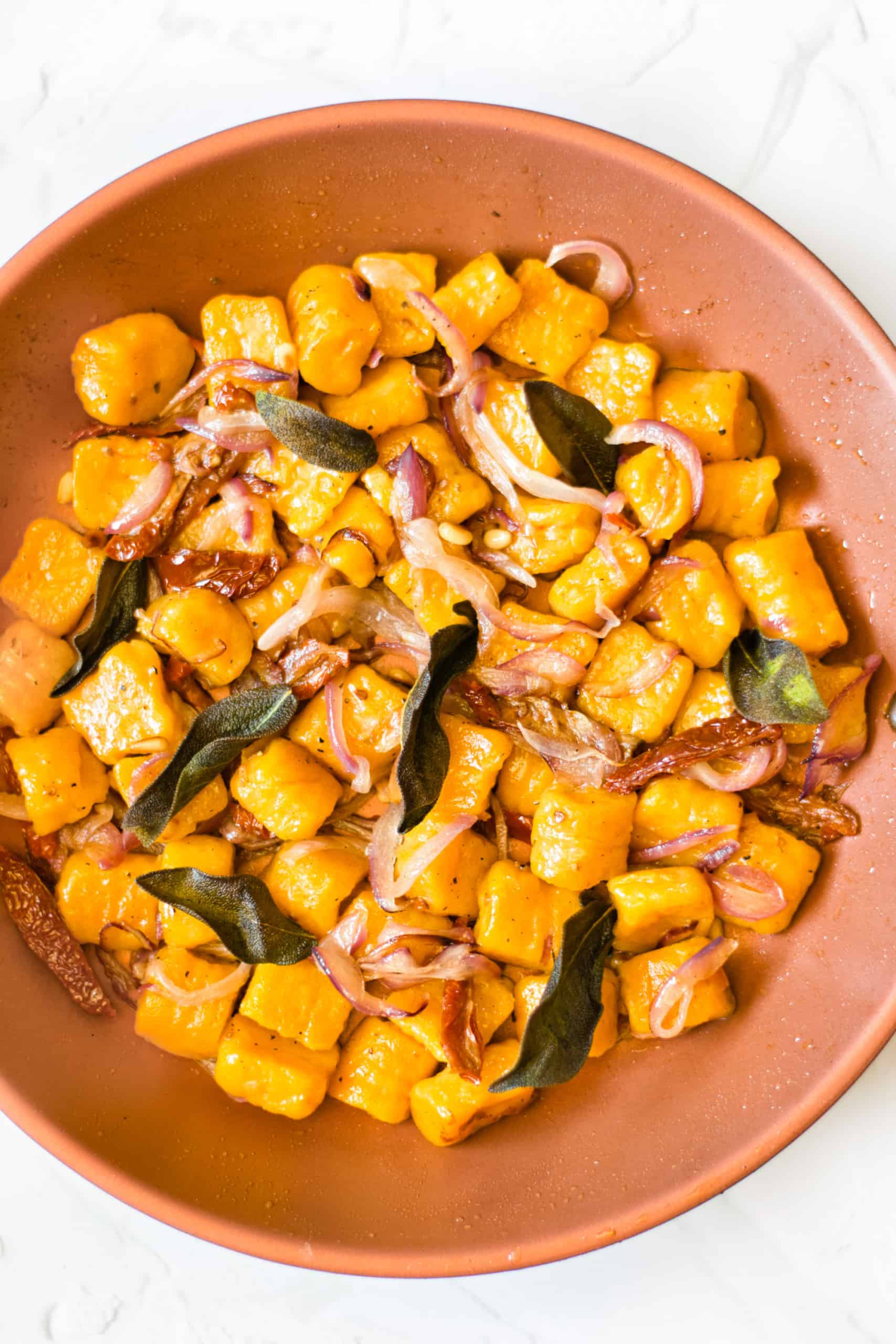 Gluten-free dairy-free sweet potato gnocchi in a pink bowl.
