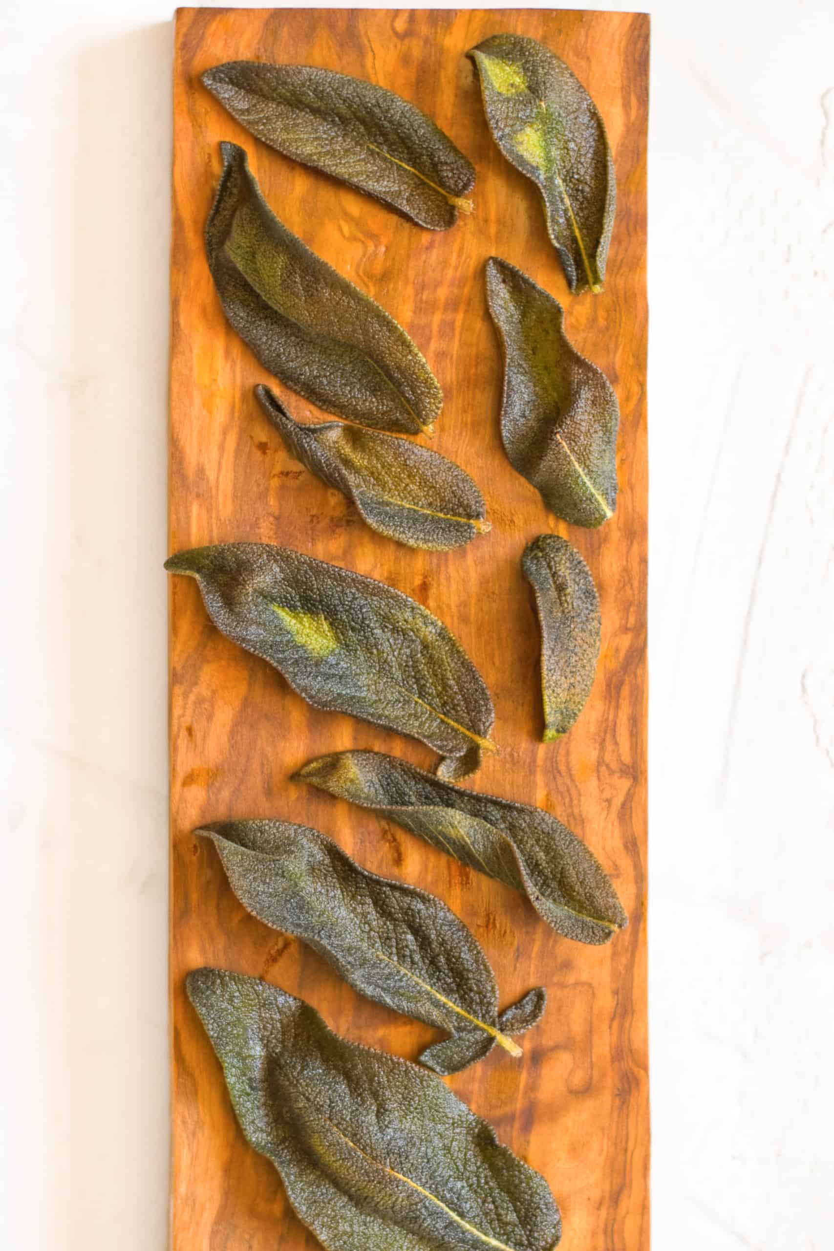 Crispy fried sage on wooden board.
