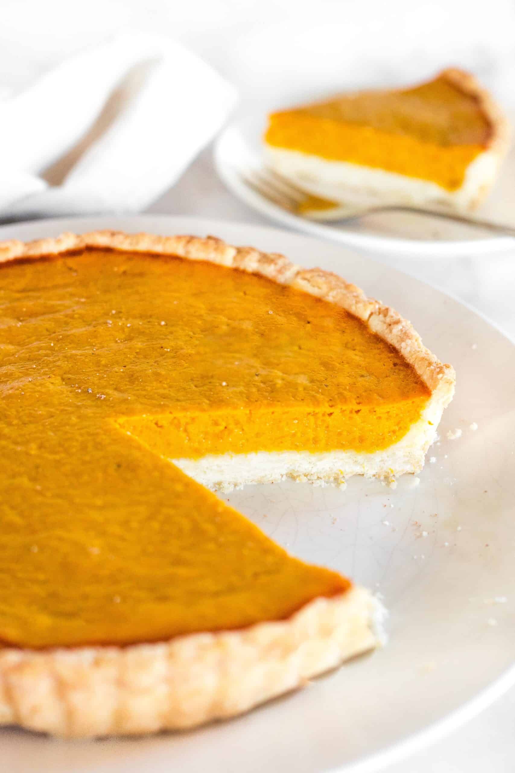 A half-eaten gluten-free sweet potato pie on a plate.