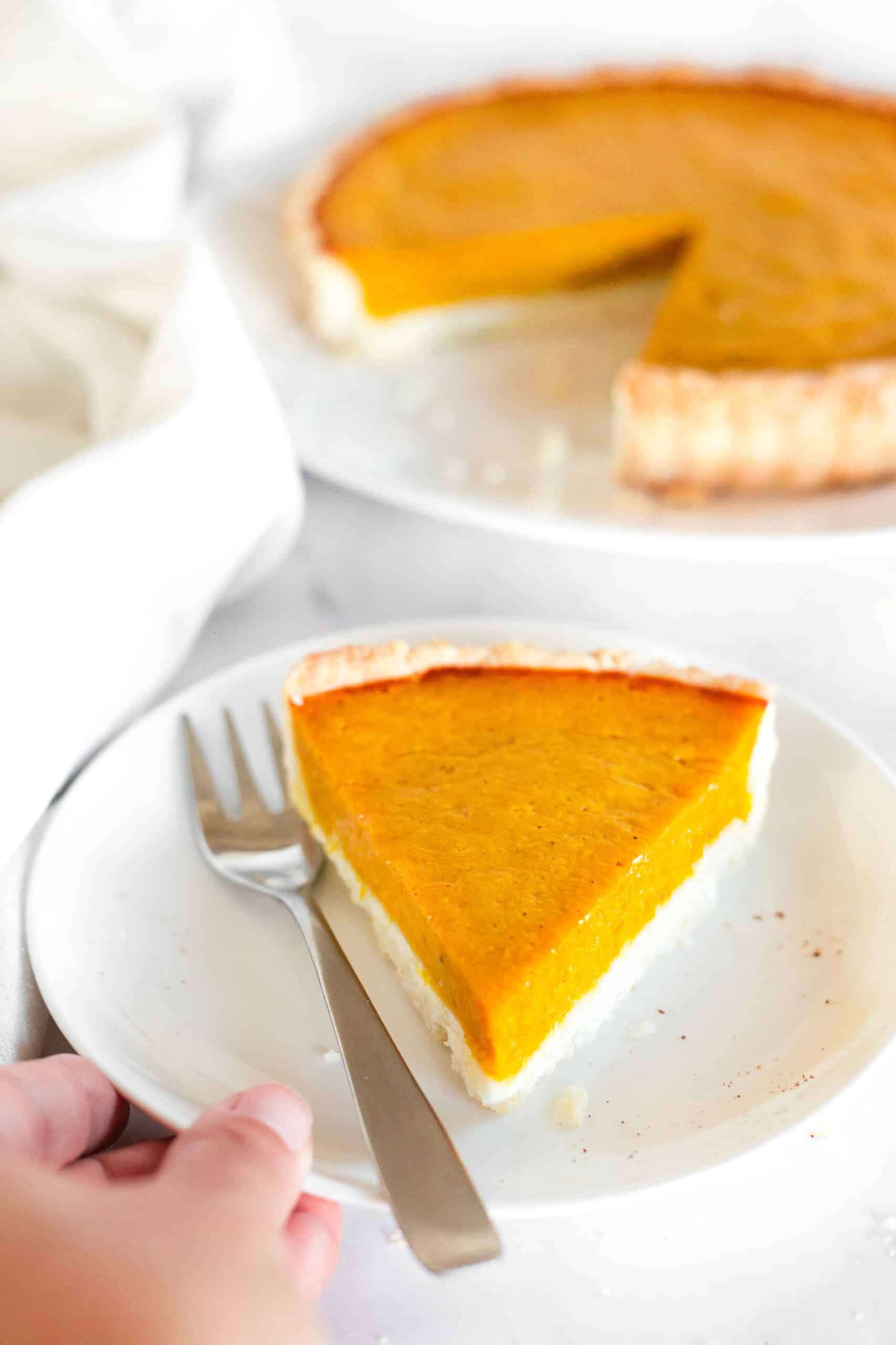 A fork and a slice of sweet potato pie on a plate.