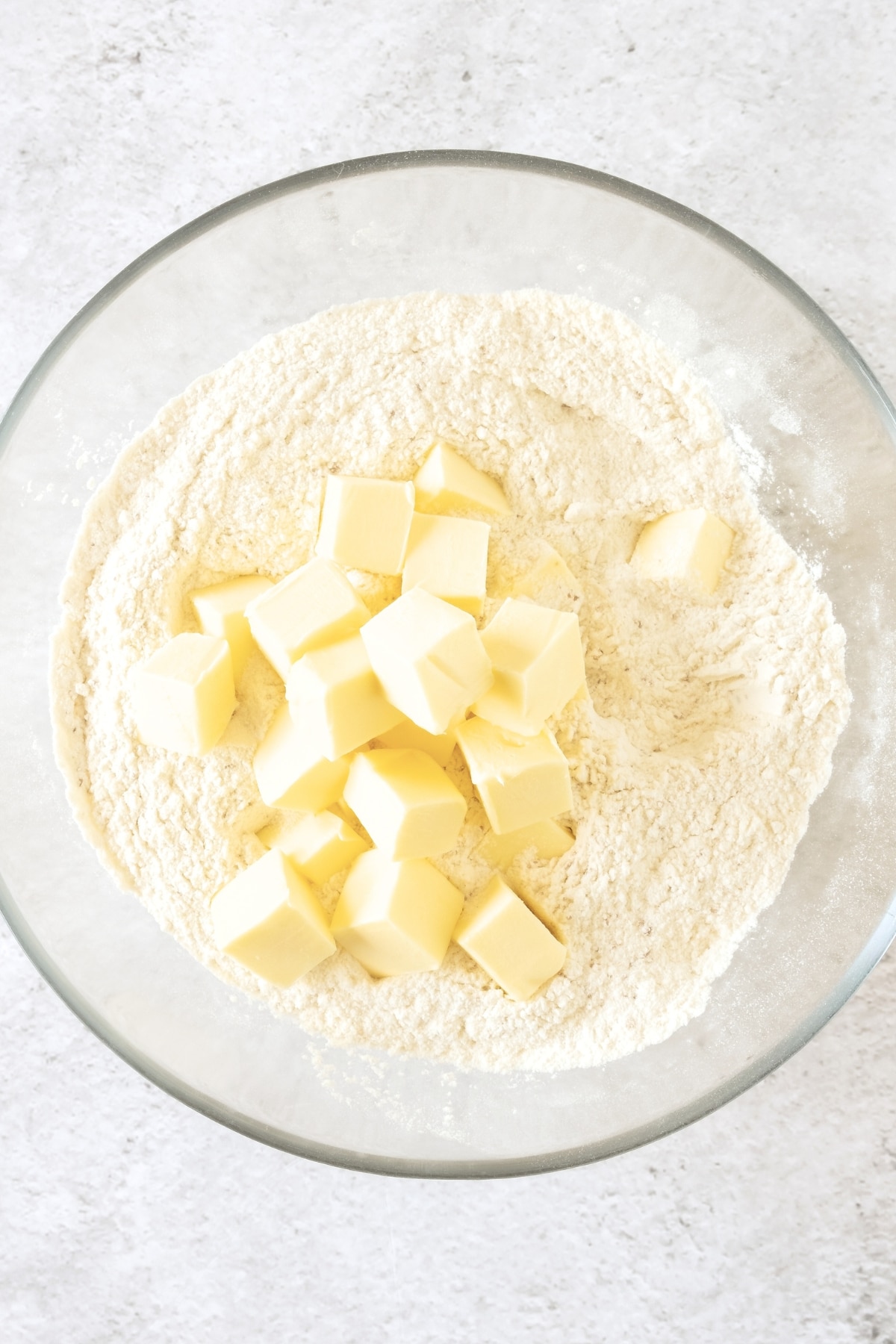 Cubed butter on top of flour in mixing bowl.
