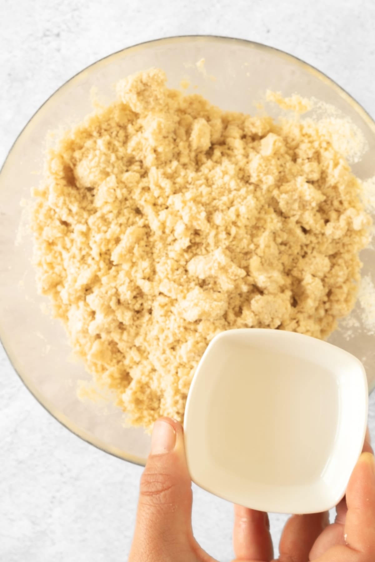 Pouring water into dough mixture.