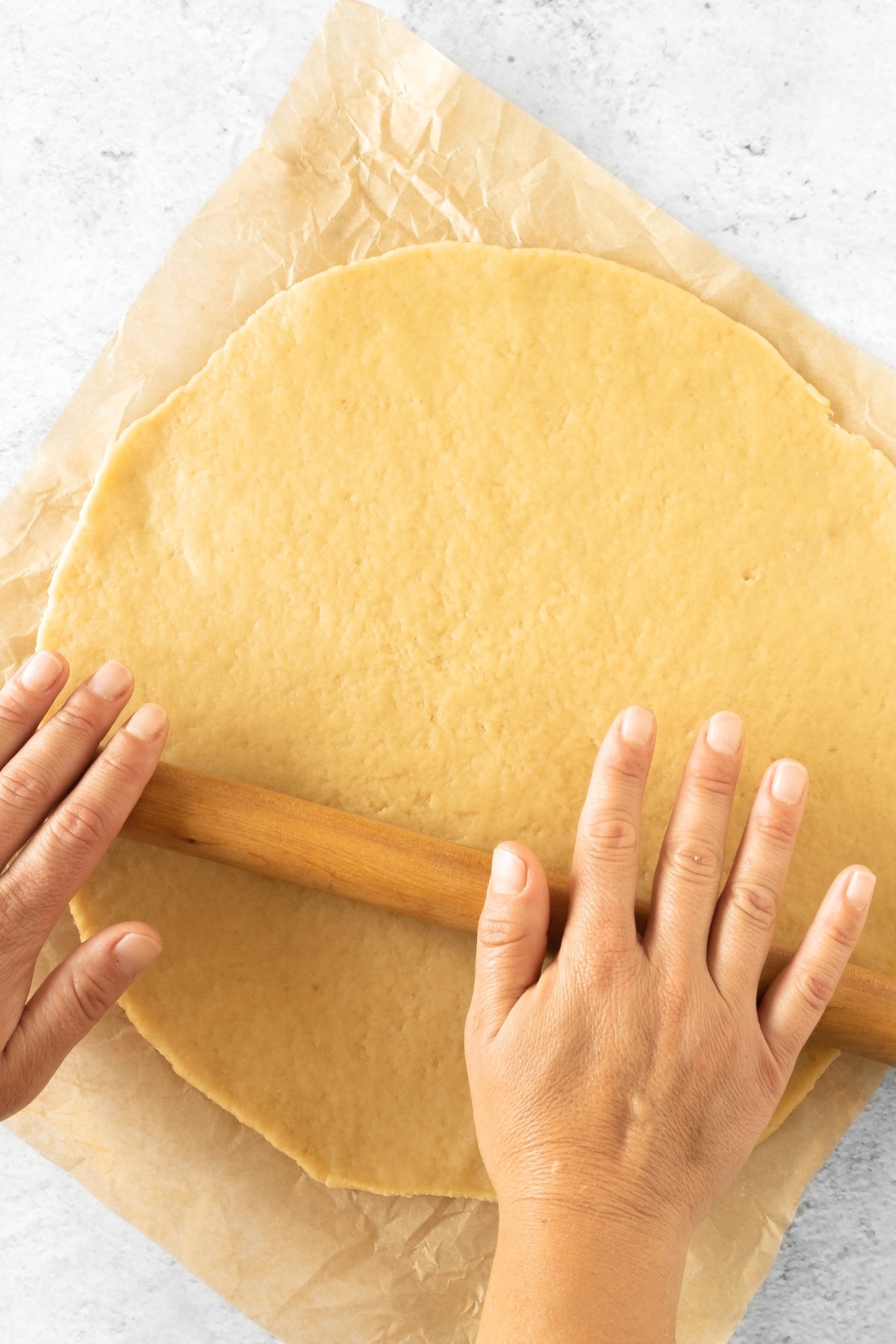Rolling out gluten-free tart dough with rolling pin.