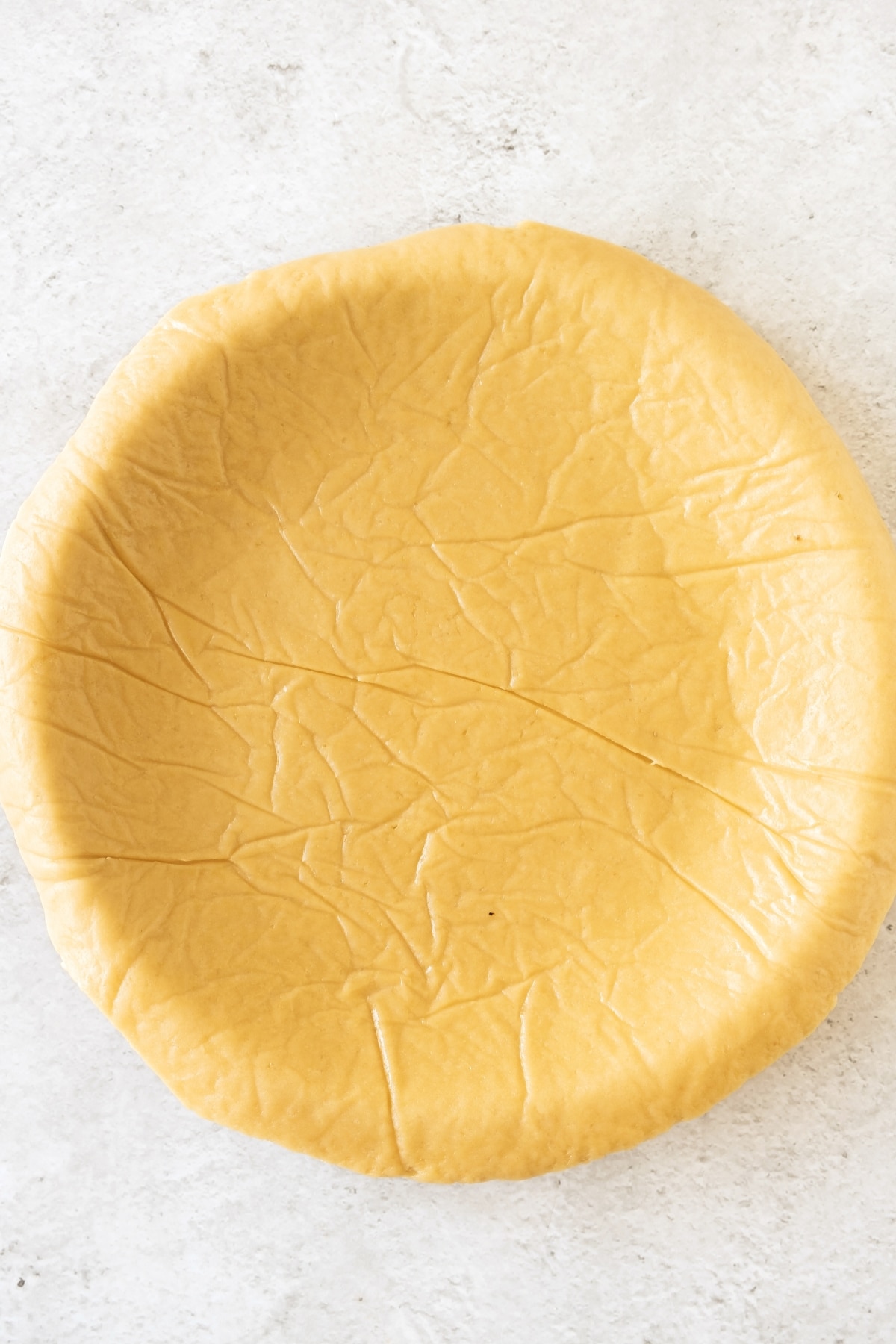 Rolled tart dough with parchment paper.