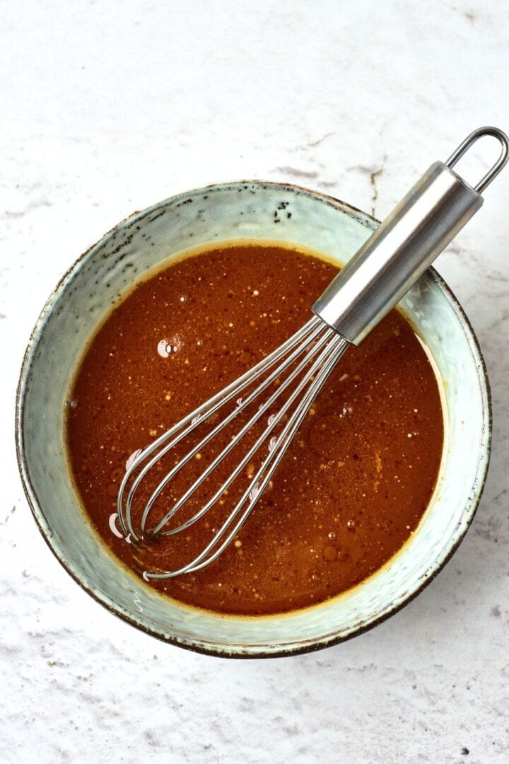 Whisking homemade gluten-free teriyaki sauce in bowl