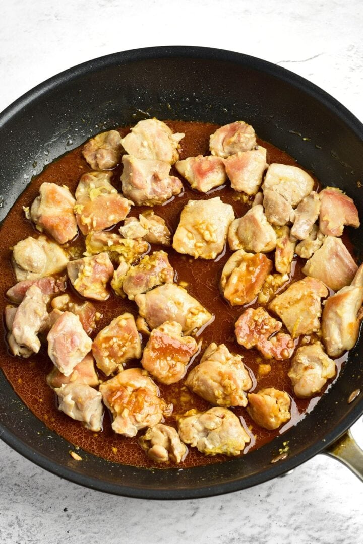 Browned chicken pieces with brown sauce in skillet