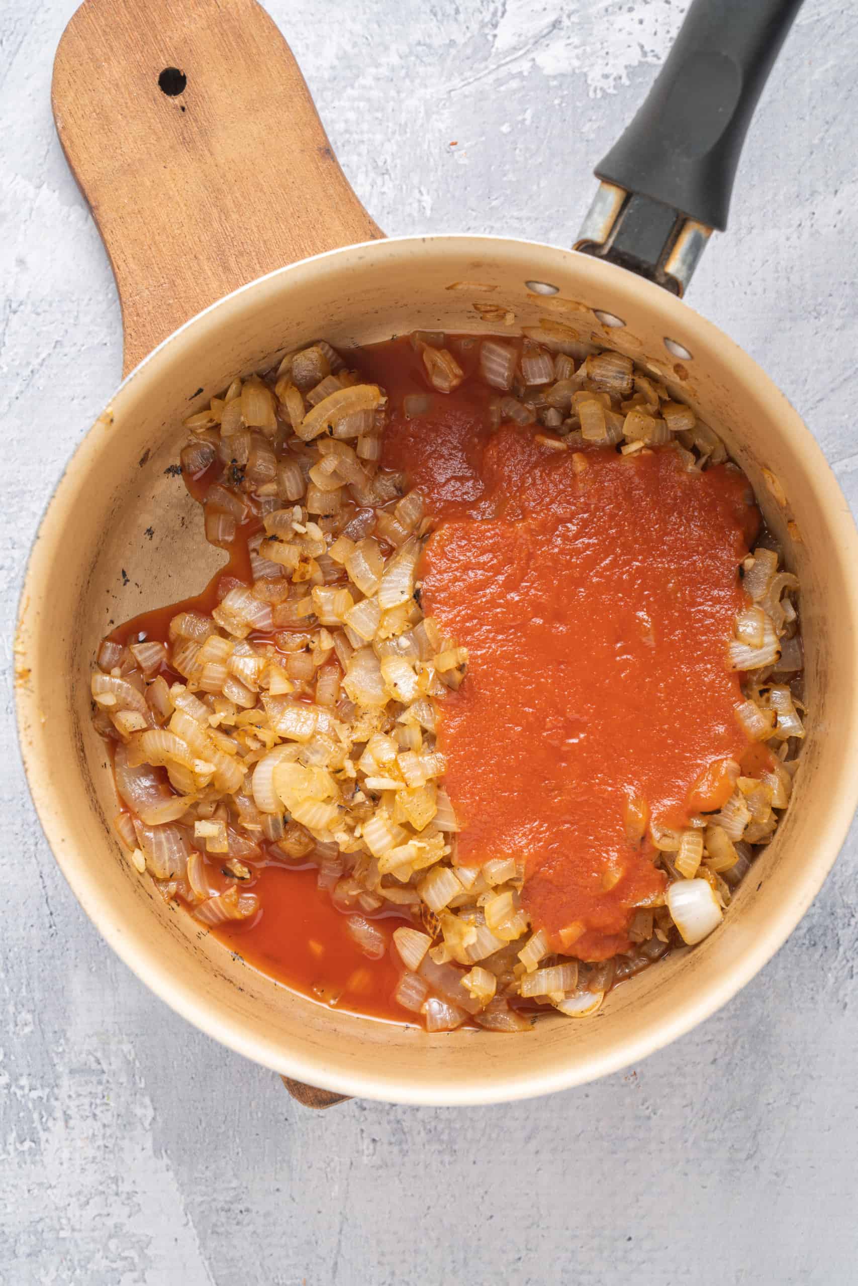 Caramelized onions and tomato sauce in a saucepan.