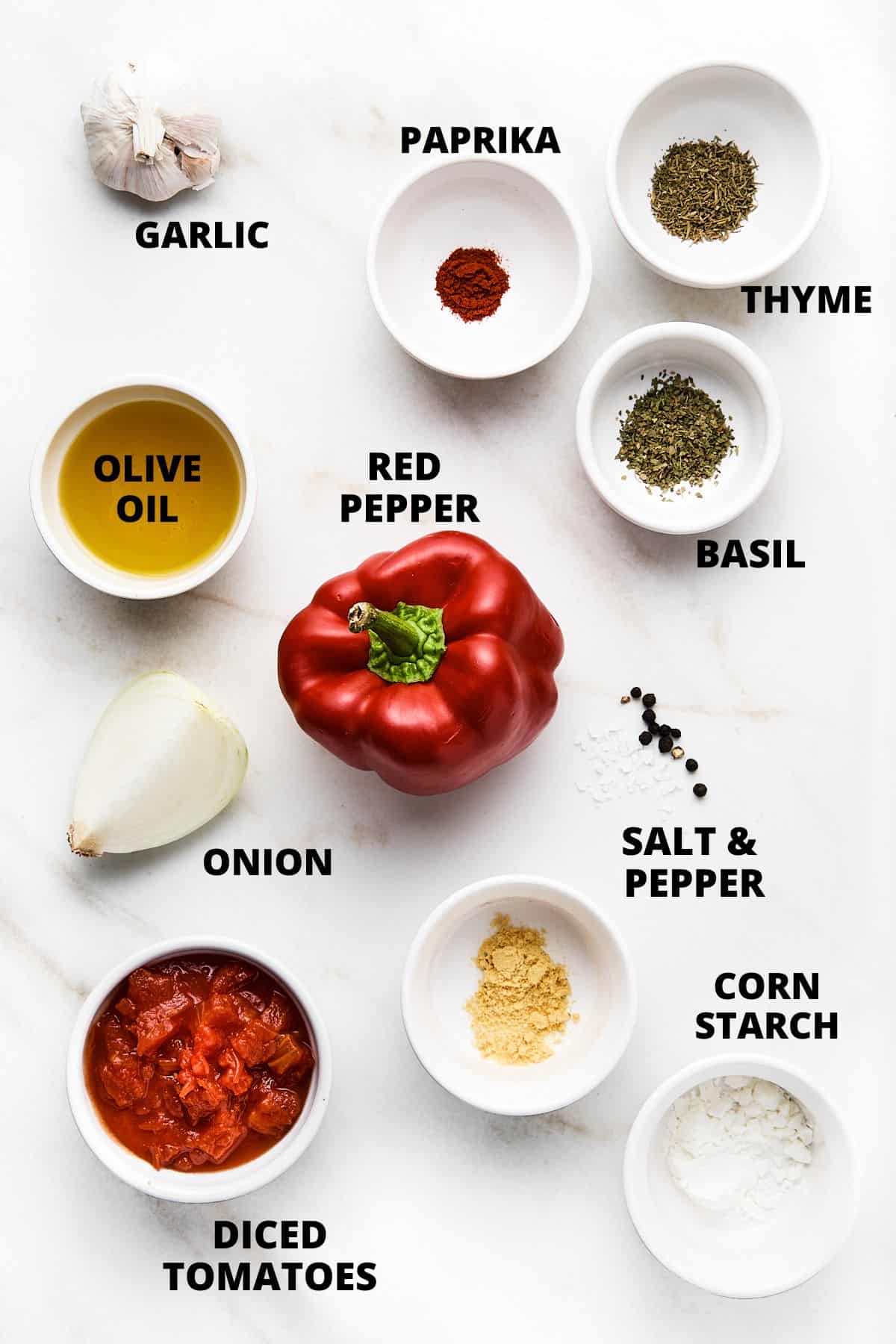 Ingredients required for making gluten-free tomato soup recipe on marble board.