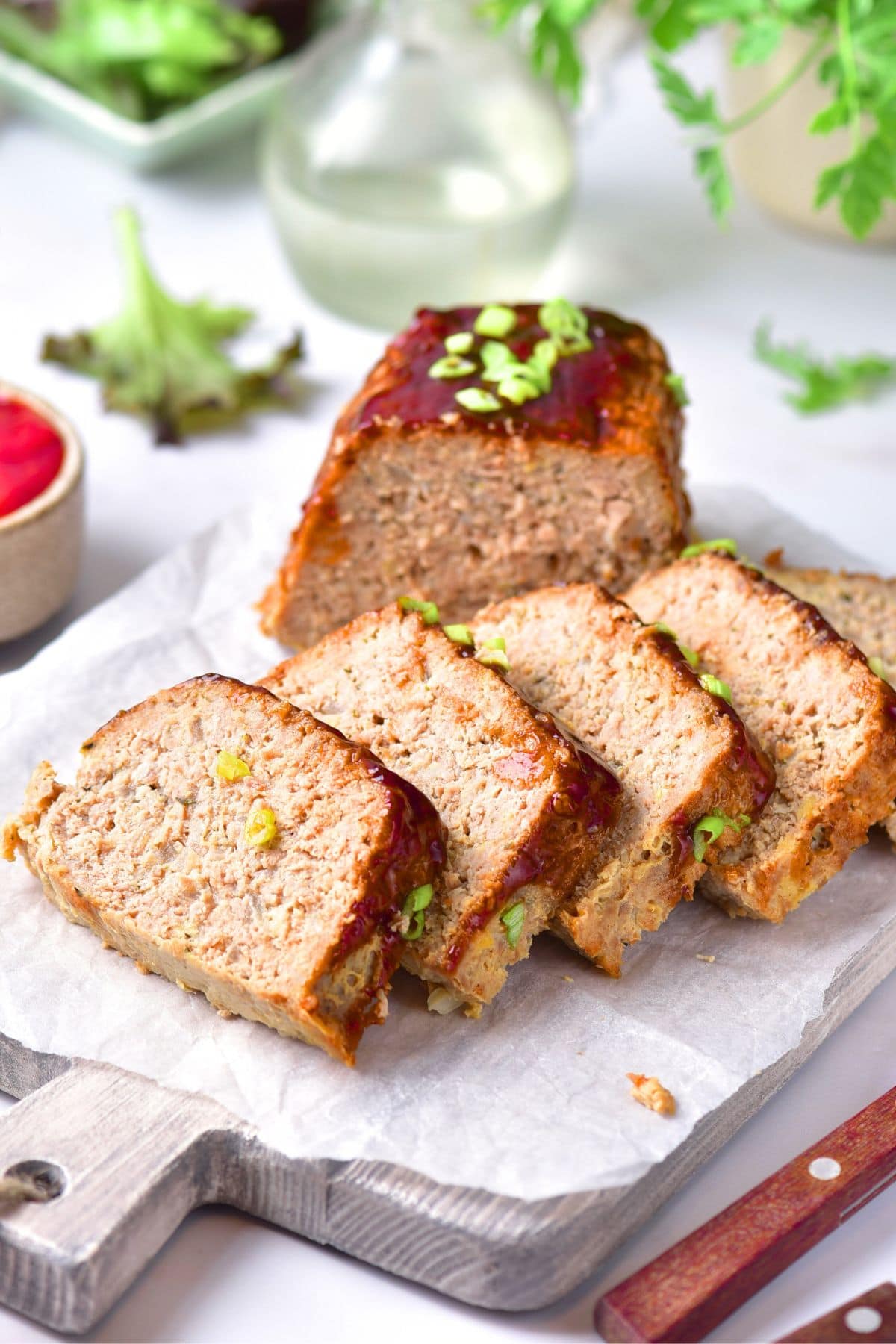 Sliced gluten-free ground turkey meatloaf on parchment-lined board.
