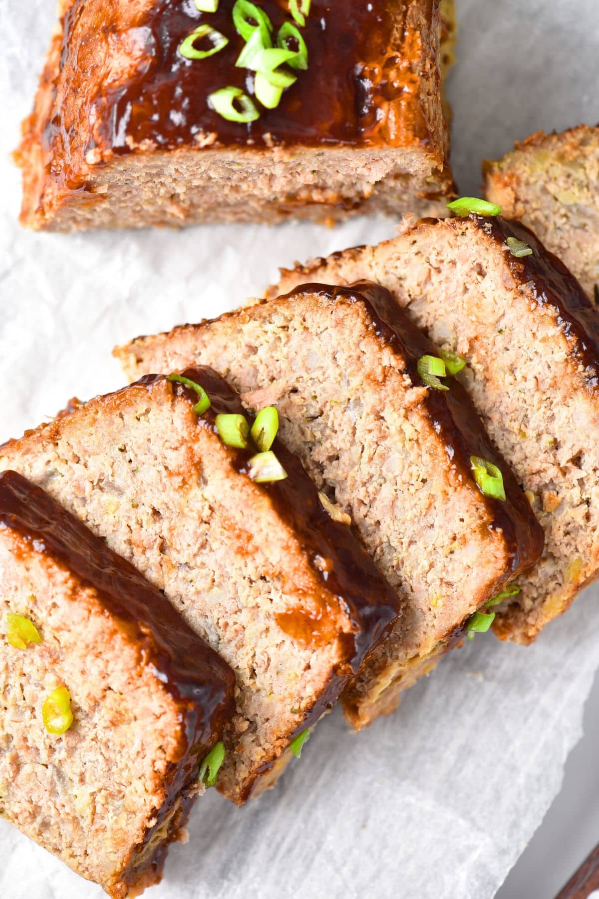 Slices of turkey gluten-free meatloaf on parchment paper.