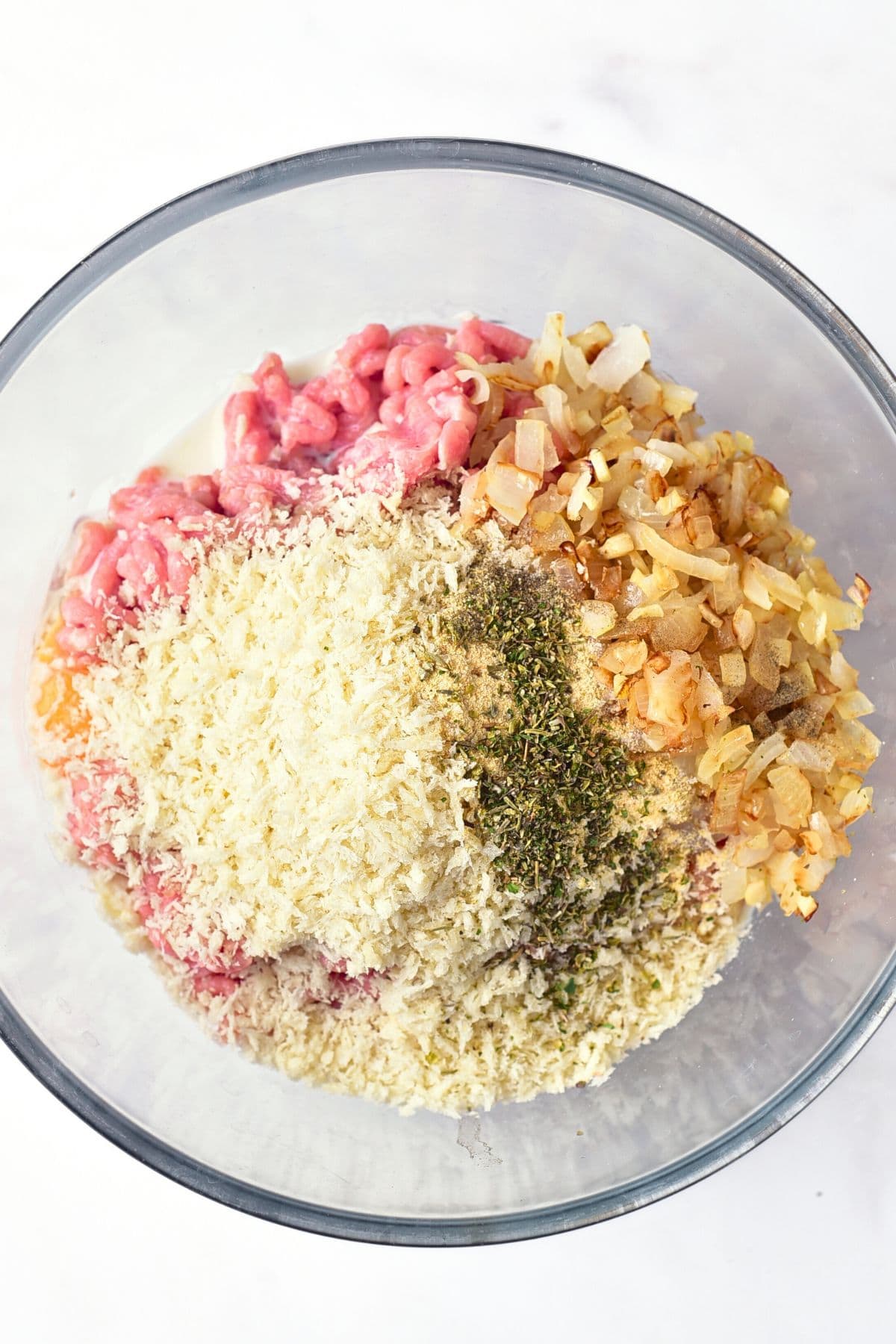 A bowl with mixture of spices, ground meat and panko breadcrumbs