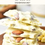 A stack of white chocolate almond bark on wooden plate