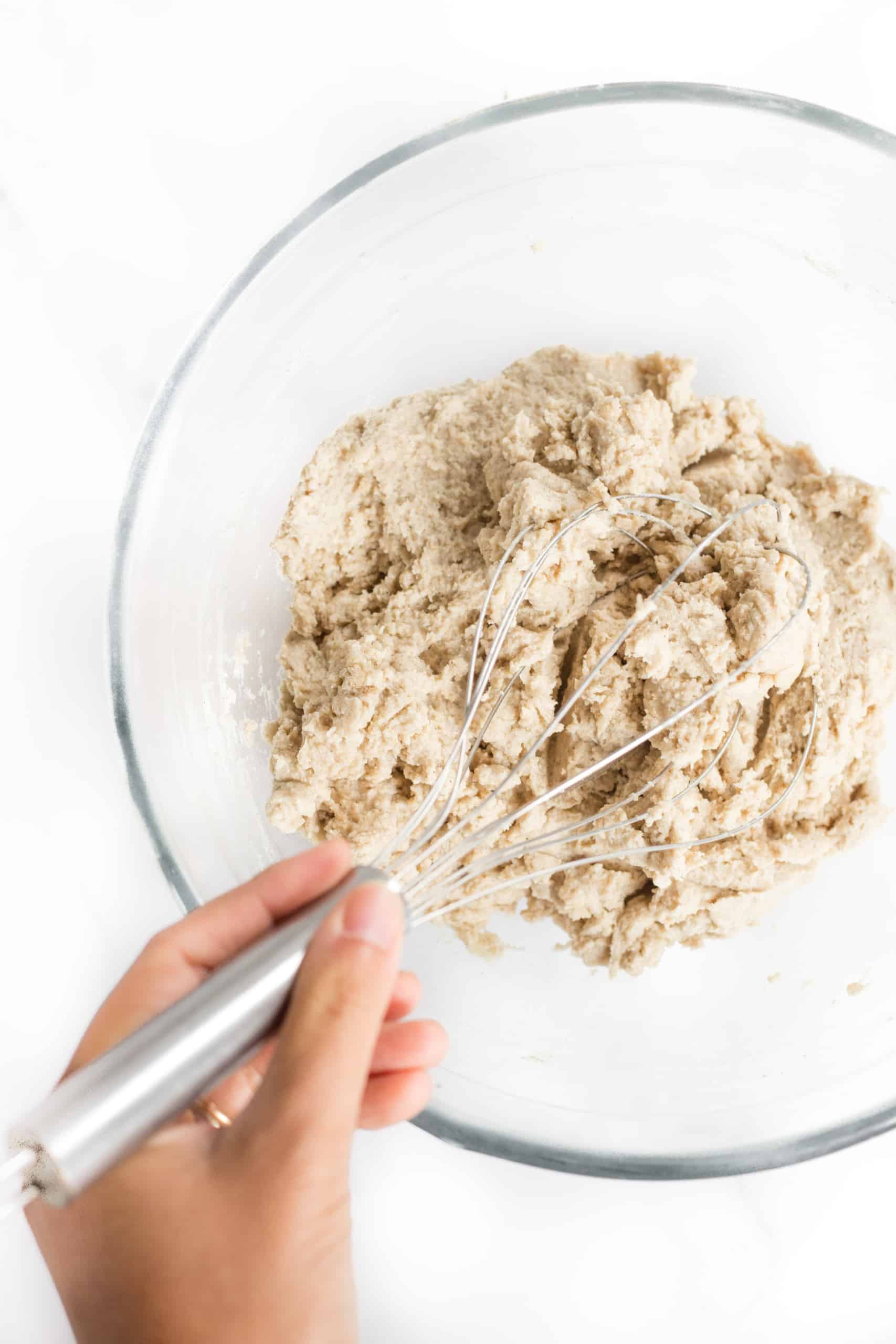 Mixing gluten-free whole grain bread dough in large glass bowl.