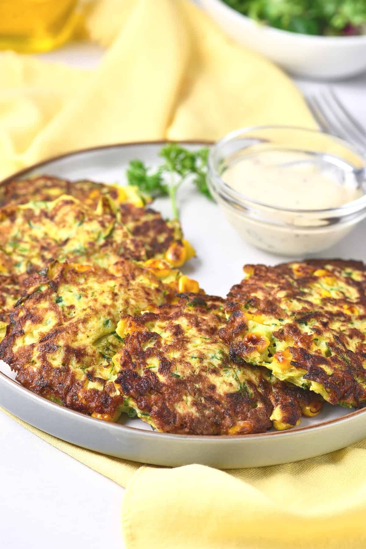 A plate of zucchini fritters with corn