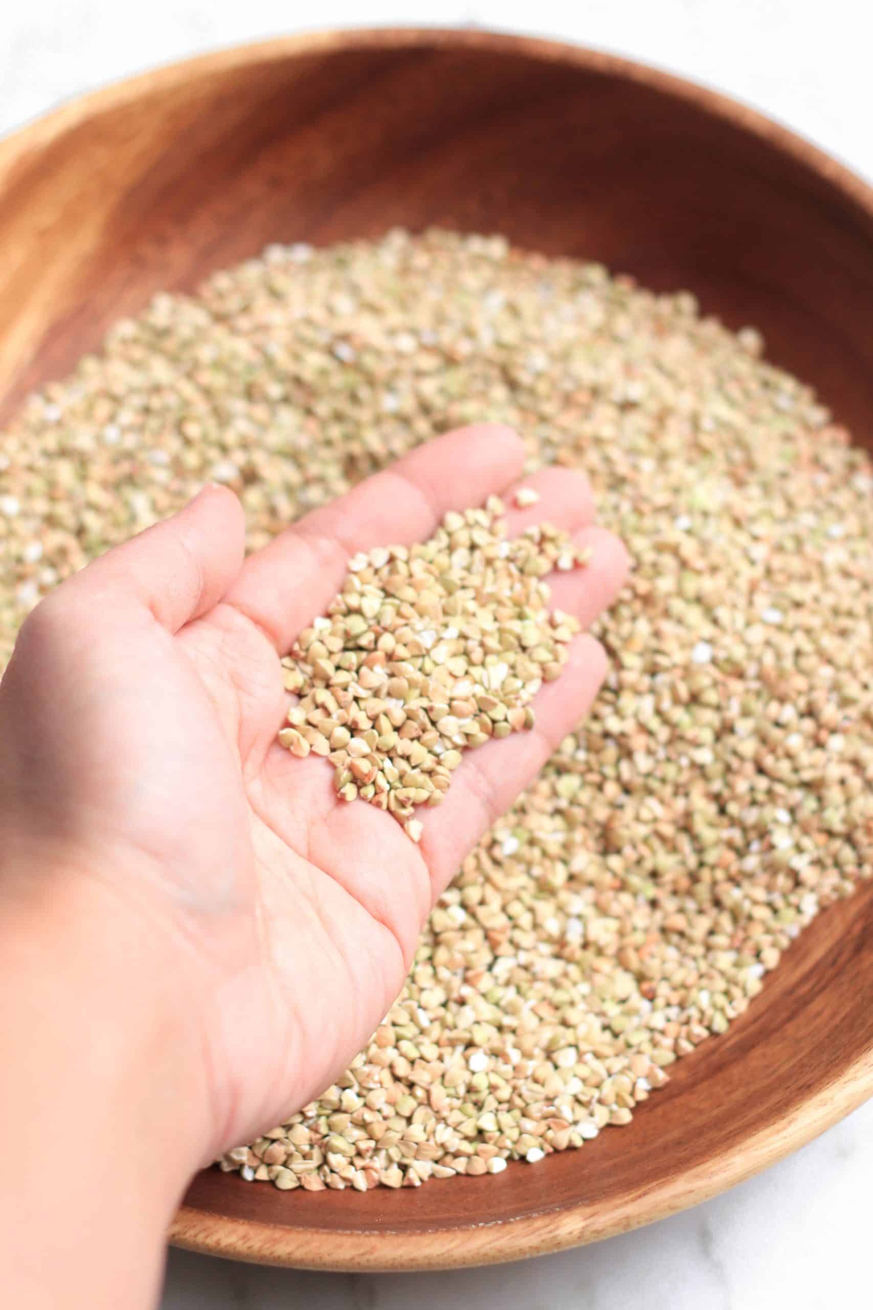 Holding up a handful of hulled buckwheat groats.