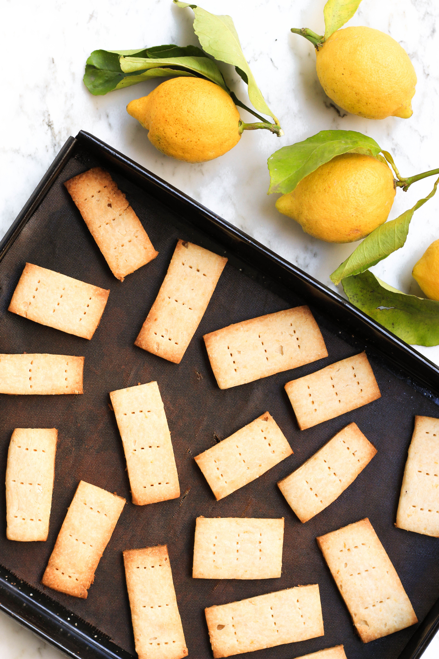 Freshly baked gluten-free shortbread cookies on parchment-lined baking sheet.