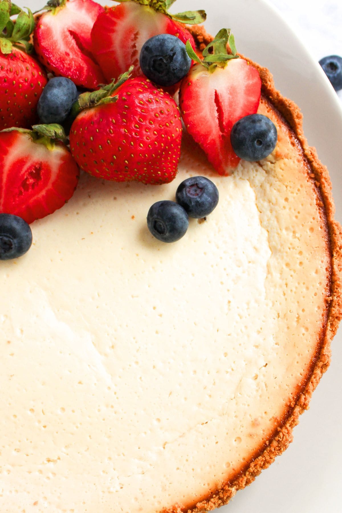 Top down view of Greek yogurt cheesecake topped with fresh berries