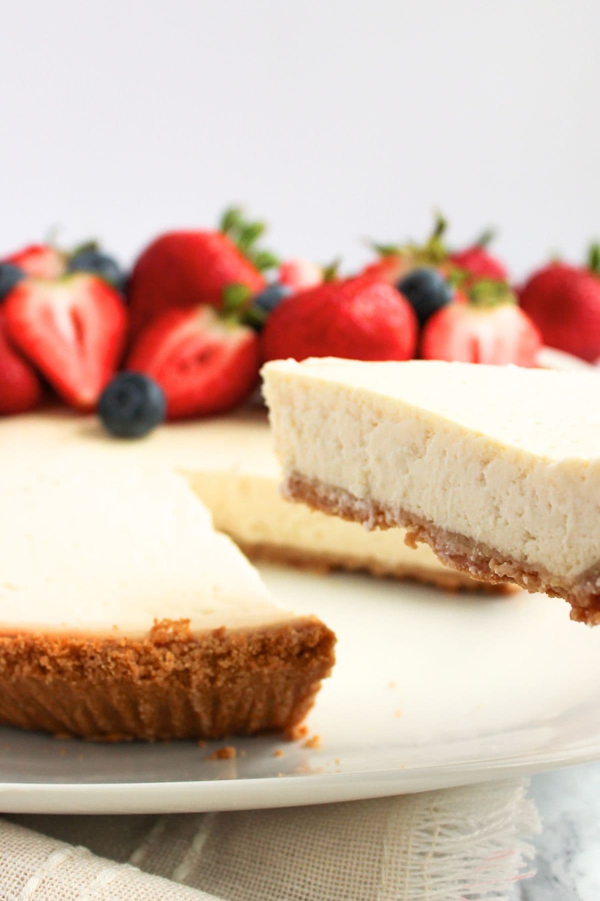Reaching for a slice of Greek yogurt cheesecake from a plate.