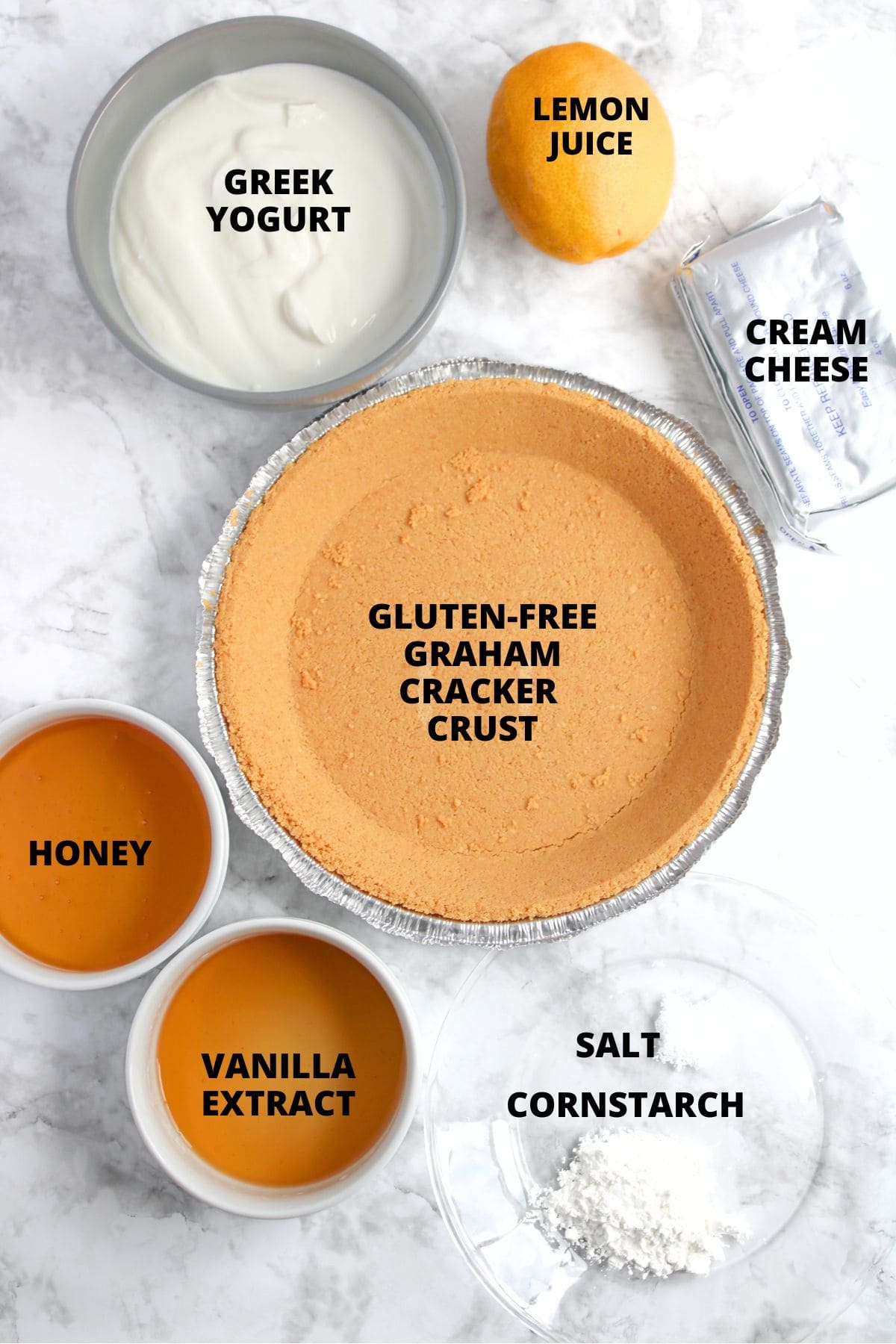 Ingredients for greek yogurt cheesecake recipe laid out on marble board.