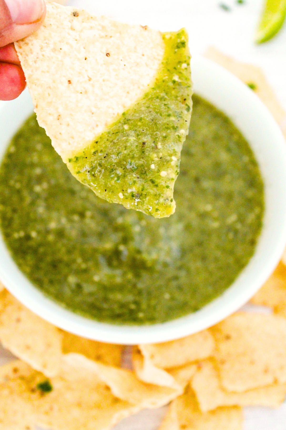 Dipping a tortilla chip into homemade salsa verde