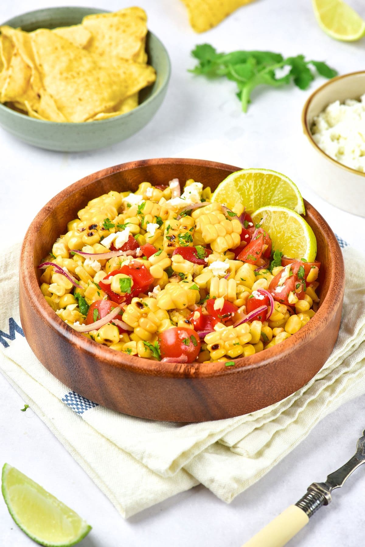 Mexican Street Corn Salad (Gluten-Free, Dairy-Free Option) A bowl of Mexican street corn salad on a kitchen towel