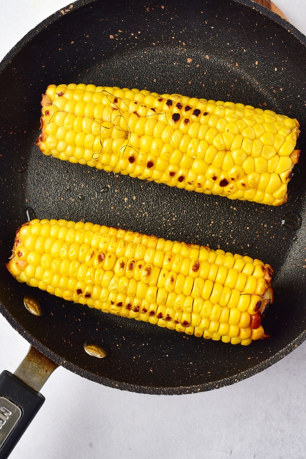 Grilled Corn Salad with Cilantro Lime Dressing Charring corn on the cob in a skillet