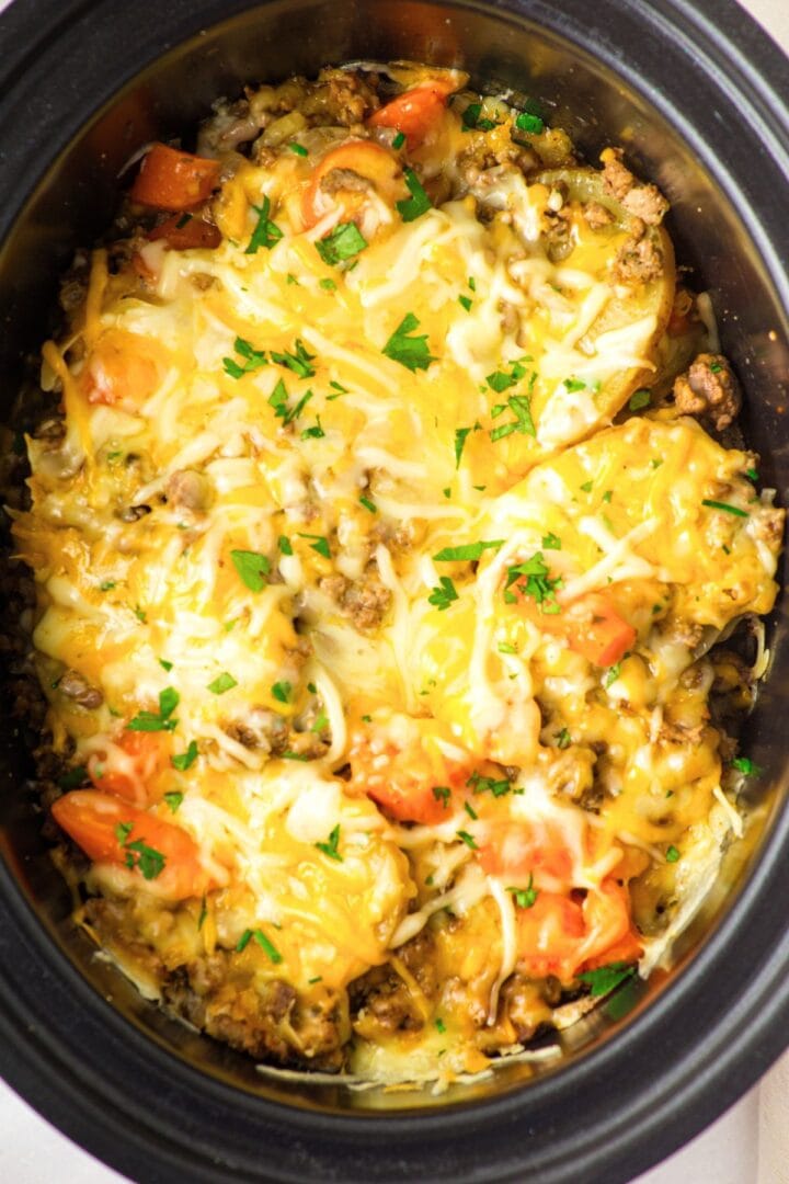 Up close view of crockpot ground beef and potato casserole topped with melted cheese
