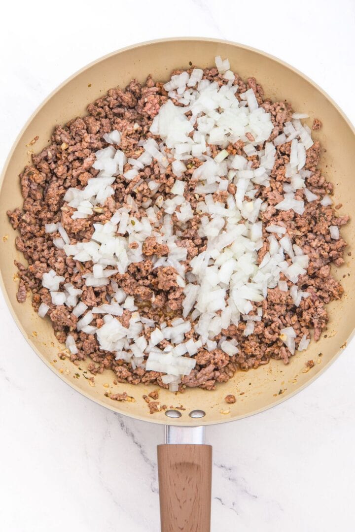 Sautéed ground beef and diced onions in skillet