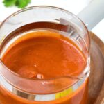 A glass jar with guajillo pepper sauce.