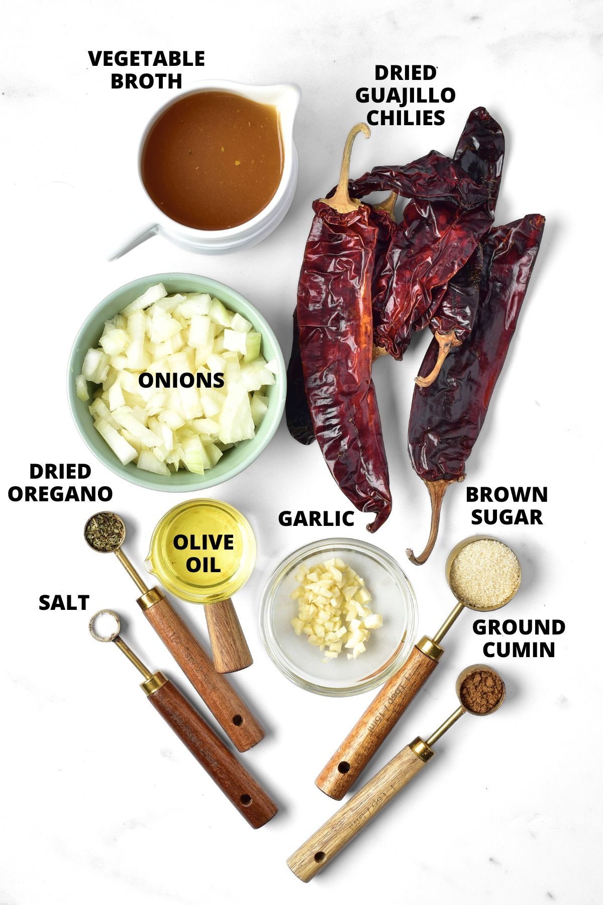 Ingredients for guajillo sauce recipe laid out on marble board.
